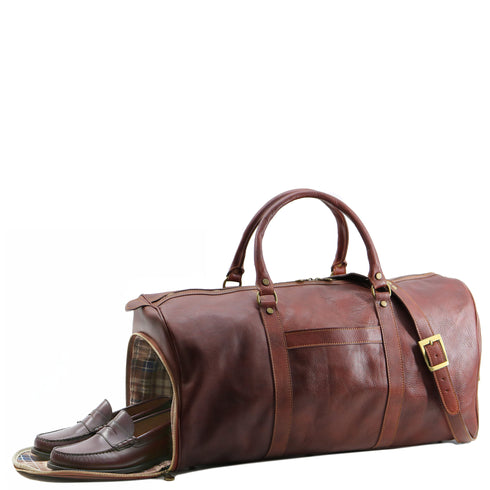 This is the Floto Lugano Weekender Duffle Bag with a built-in shoe compartment. The shoe compartment zips open on the side of the bag for easy adds. This Lugano is pictured in Brown. Shoe compartment view.