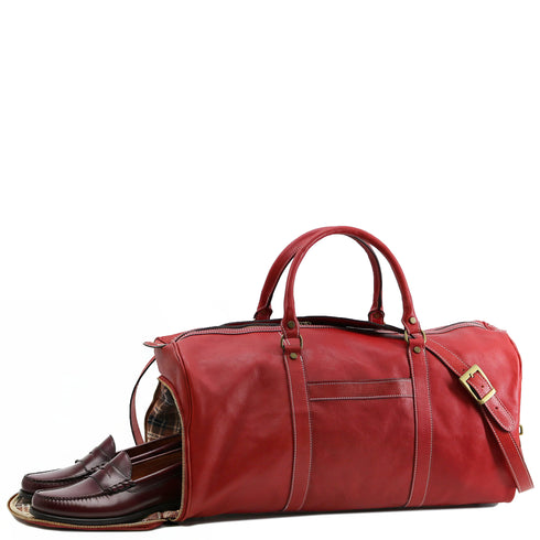 This is the Floto Lugano Weekender Duffle Bag with a built-in shoe compartment. The shoe compartment zips open on the side of the bag for easy adds. This Lugano is pictured in red. Shoe compartment view.
