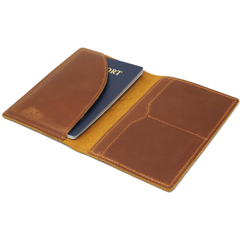 Brown leather passport holder with a passport inside on a white background
