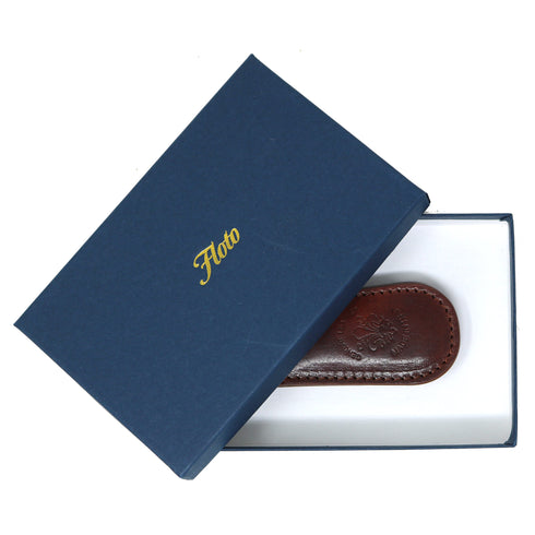 Blue box with 'Floto' branding containing a brown leather item on a white background