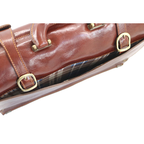 Brown leather bag with gold buckles on a white background