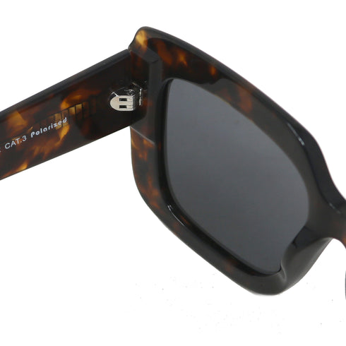 Sunglasses with tortoiseshell frame and dark lenses on a white background