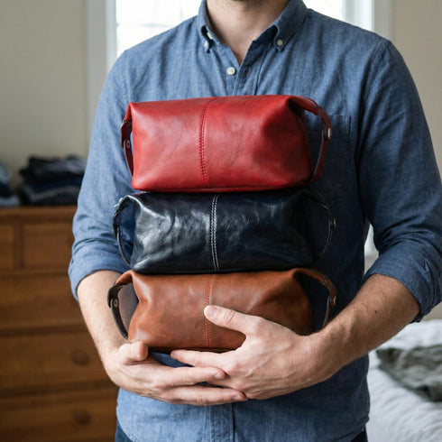 Person holding three leather bags of different colors