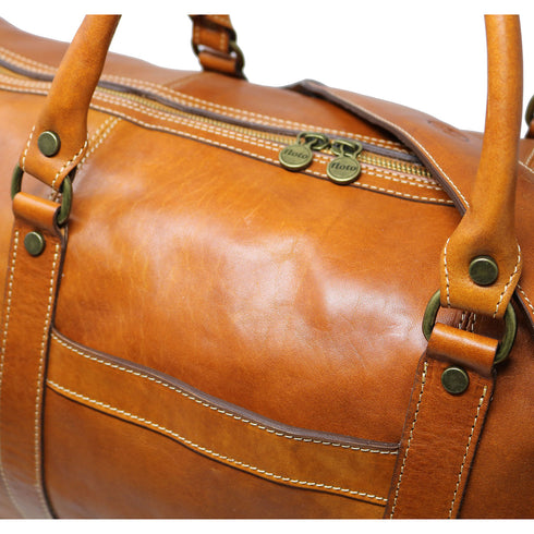 This is the Floto Lugano Weekender Duffle Bag with a built-in shoe compartment. The shoe compartment zips open on the side of the bag for easy adds. This Lugano is pictured in Olive Brown. Close up view.