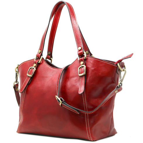 The Floto Ischia Shoulder Bag is a women's leather bag that is handcrafted in Italy. It has comfortable shoulder straps that are adjustable and includes a detachable crossbody strap. This is the Ischia Shoulder Bag in Tuscan Red - side view.