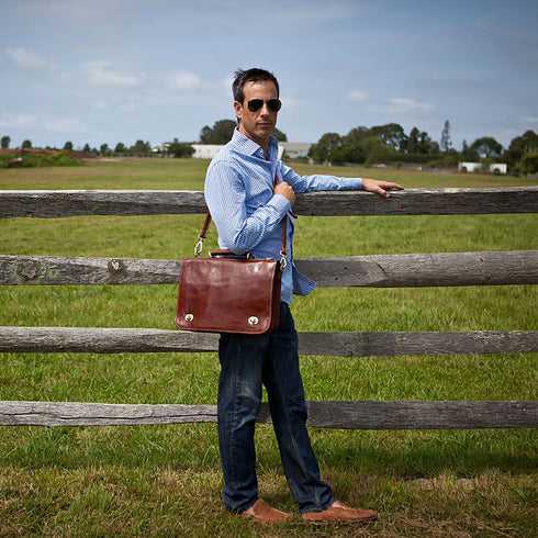 The Floto Roma Messenger Bag is a soft-sided leather bag that is made in Italy with full grain hand-stained leather. This messenger bag has an outside zip pocket, inside pen organizer, and a detachable shoulder strap. This is the Roma Messenger in Vecchio Brown - Hamptons.