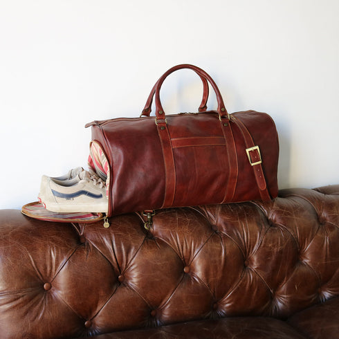 This is the Floto Lugano Weekender Duffle Bag with a built-in shoe compartment. The shoe compartment zips open on the side of the bag for easy adds. This Lugano is pictured in Vecchio Brown on a leather sofa.